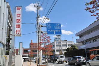 【王寺駅】より 25 号線を南下し、【王寺町役場前】交差点を右折してください。※左手の京都銀行を通過し、T字路の郵便局・NTTが目印です。
